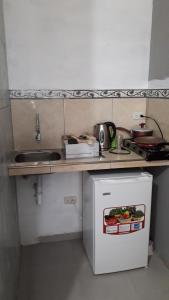 a small kitchen with a sink and a small refrigerator at Habitacion Vacacional Camboriu in Salinas
