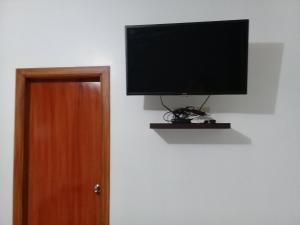 a flat screen tv hanging on a wall next to a door at Habitacion Vacacional Camboriu in Salinas
