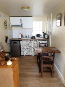 uma cozinha com uma mesa e uma cozinha com um fogão em Simone's Tiny House em Montpellier