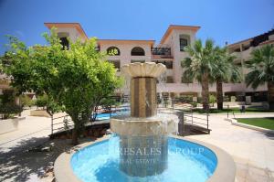 a water fountain in front of a building at Queens Gardens suite by the sea, pool and mall in Nea Paphos