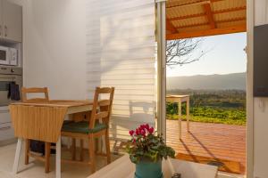 eine Küche mit Tisch und Stühlen und ein Balkon in der Unterkunft הגורן in Kefar Szold