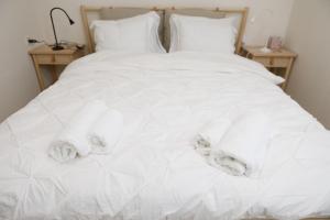 een wit bed met handdoeken erop bij הגורן in Kefar Szold