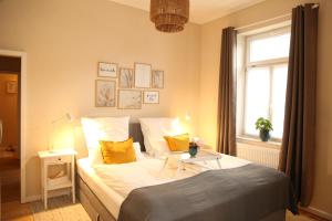 Un dormitorio con una cama con almohadas amarillas y una ventana en Villa Adelinde, en Stromberg