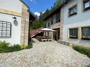 patio ze stołem i parasolem obok budynku w obiekcie Penzion Stodola w mieście Weisswasser in Böhmen