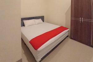 1 dormitorio con 1 cama con manta roja en RedDoorz Syariah near Sentani City Square, en Weversdorp