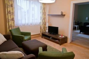 sala de estar con sofá, sillas y TV en Slovakia; space, tranquility and plenty of opportunities! Be welcome in Strawberry House!, en Brzotín