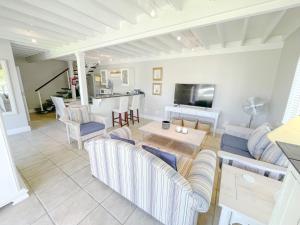 een woonkamer met een bank en een tafel bij Sea-Lets in Keurboomstrand