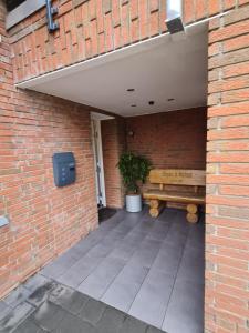 una pared de ladrillo con un banco en un patio en Ferienwohnung / Messeunterkunft en Willich