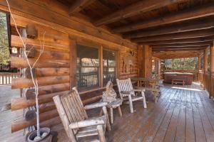 a porch of a log cabin with chairs and a table at Moose Tracks cabin in Pigeon Forge