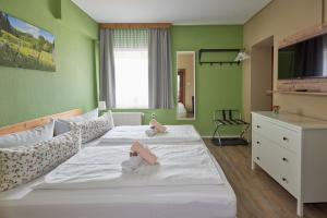 een slaapkamer met 2 bedden en groene muren bij Gasthaus Stollmühle in Stützengrün
