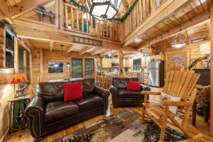 a living room with leather furniture in a log cabin at Moose Tracks cabin in Pigeon Forge