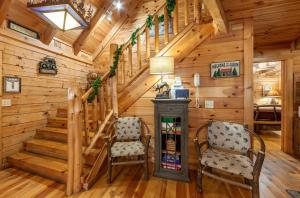 una habitación con 2 sillas y una escalera en una cabaña en Moose Tracks cabin, en Pigeon Forge 24 fotos más