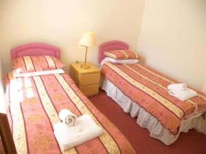 um quarto com duas camas e um candeeiro sobre uma mesa em Royal Mile, Edinburgh - 2 Bedroom Apartment em Edinburgo