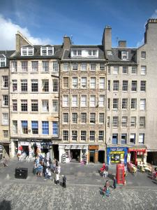 um grande edifício com pessoas sentadas à sua frente em Royal Mile, Edinburgh - 2 Bedroom Apartment em Edinburgo