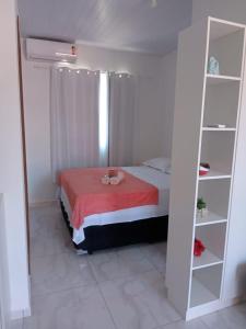 1 dormitorio con cama y estante para libros en Residencial Campeche 1 en Florianópolis