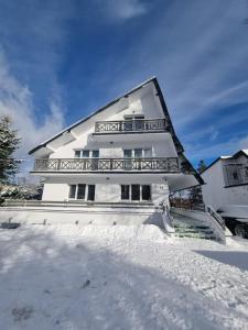 una casa bianca con la neve davanti di Snow Queen a Szklarska Poręba