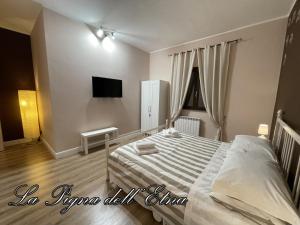 a bedroom with a bed and a tv on the wall at La Pigna dell'Etna in Nicolosi