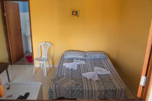 a bedroom with a bed and a chair in it at Casa Morada da Praia 03 in Maragogi