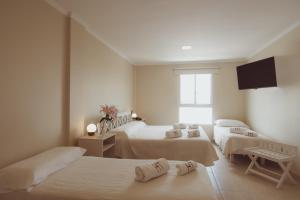 - une chambre avec 2 lits et une télévision murale dans l'établissement Hotel Tonight, à Salta