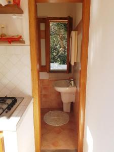 ein kleines Bad mit einem Waschbecken und einem Fenster in der Unterkunft VILLA AURA in Lipari