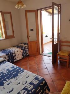 Zimmer mit 2 Betten und Glasschiebetür in der Unterkunft VILLA AURA in Lipari