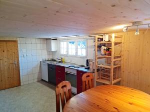 a kitchen with a wooden table and a wooden ceiling at Grosses Ferienhaus für traumhafte Familienferien im Appenzellerland in Speicher