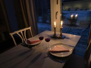 a table with two glasses of wine and two candles at Strandboende in Beddinge Strand