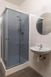 a bathroom with a glass shower and a sink at Apartmány SKI KRASLICE - NOVĚ OTEVŘENO in Kraslice