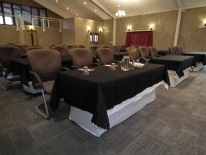 a conference room with tables and chairs with black table cloth at Lanseria Country Estate in Lanseria +181 photos
