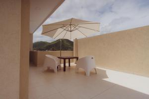 a patio with a table and two chairs and an umbrella at Hotel Tonight in Salta