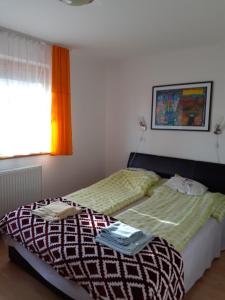 1 dormitorio con 2 camas individuales y ventana en Szahara Vendégház en Kerekegyháza