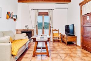 sala de estar con sofá, TV y mesa en Los Huertos de Segura, en Segura de la Sierra