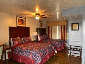 a hotel room with two beds and a ceiling fan at Delux Inn in Clearwater