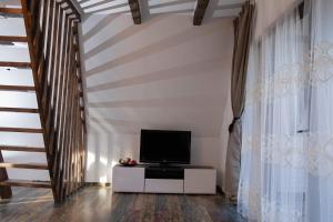 ein Wohnzimmer mit einem TV und einer Treppe in der Unterkunft Cabana La Bica in Măgureni