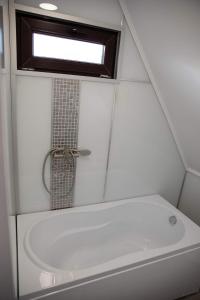 a small bathroom with a tub and a sink at Cabana La Bica in Măgureni
