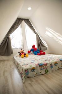 ein Schlafzimmer mit einem Bett mit ausgestopften Tieren darauf in der Unterkunft Cabana La Bica in Măgureni