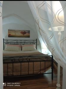 - une chambre avec un lit à baldaquin blanc dans l'établissement Il Nido della Calandra, à Tuglie