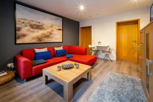 a living room with a red couch and a table at Bördeapartment 1 in Vahldorf