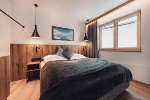 A bed or beds in a room at Alpenheim Apartment Ischgl