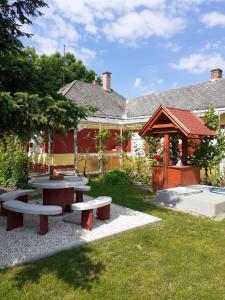 uma mesa de piquenique e um gazebo num quintal em Kereki Retro Vendégház em Kerekegyháza