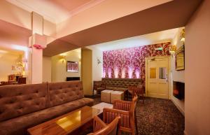 a waiting room with a couch and a table and chairs at The Parklands Hotel in Perth