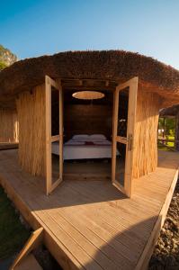 - un lit dans une cabane sur une terrasse en bois dans l'établissement Chakra Beach Kabak, à Faralya