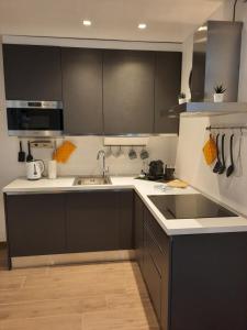 a kitchen with black and white cabinets and a sink at Sunset Lake Como con balcone vista lago in Blevio