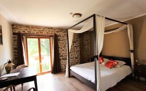 a bedroom with a canopy bed and a desk at Combrailleurs Gite in Espinasse +29 photos