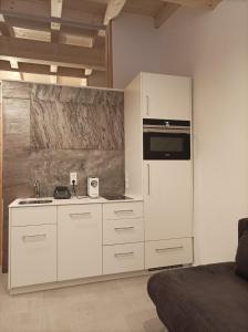 uma cozinha com armários brancos e um frigorífico em Zimmer bei Landhaus Mayr em Maurach