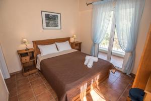 Un dormitorio con una cama y una ventana grande. en Vasilikos -Green Poros Village, en Mikros Gialos 55 fotos más