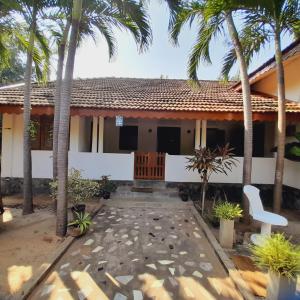 una casa con palmeras delante en Malabar home stay, en Jaffna