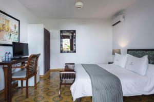 a hotel room with a bed and a television at Hotel Villa Colonial in Santo Domingo