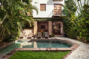 a swimming pool in the yard of a house at Hotel Villa Colonial in Santo Domingo