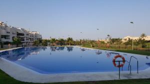 een groot blauw zwembad met een basketbalring bij Apartments Sol de Almeria Golf y Playa II in Almería
